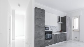 Una cocina moderna con encimera de mármol, horno empotrado y armarios grises.