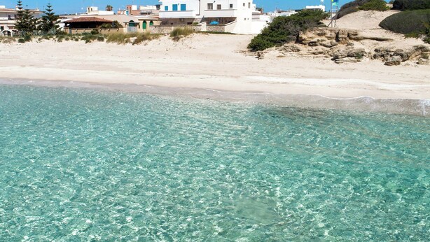 A beachfront property with clear turquoise waters, a white building with blue windows, and a sandy beach. - Casa Margot by BarbarHouse (Campomarino)