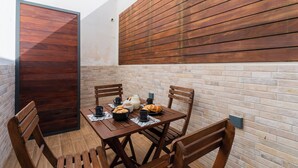 A dining area with a brick wall, wooden panel wall, and a table set with plates, cups, and a jug. - Casa Margot by BarbarHouse (Campomarino)