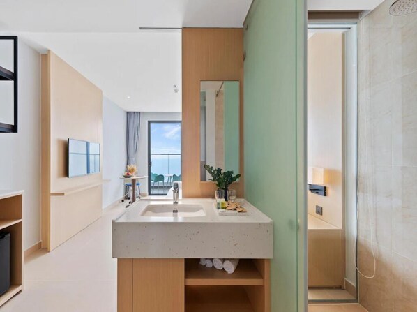 A modern bathroom with a large mirror, a sink, and a shower area.
