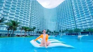 Experience the hotel's unique curved design and enjoy stunning views of the adjacent pool area with its water features and palm trees.