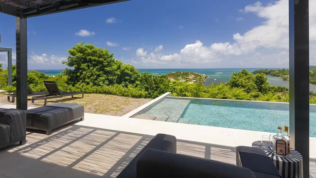 Ein Pool ohne Ende mit Blick auf den Ozean und eine tropische Landschaft.