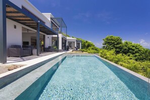 A modern house with a swimming pool, outdoor seating, and lush greenery. - Villa LALALAND  (Le François)