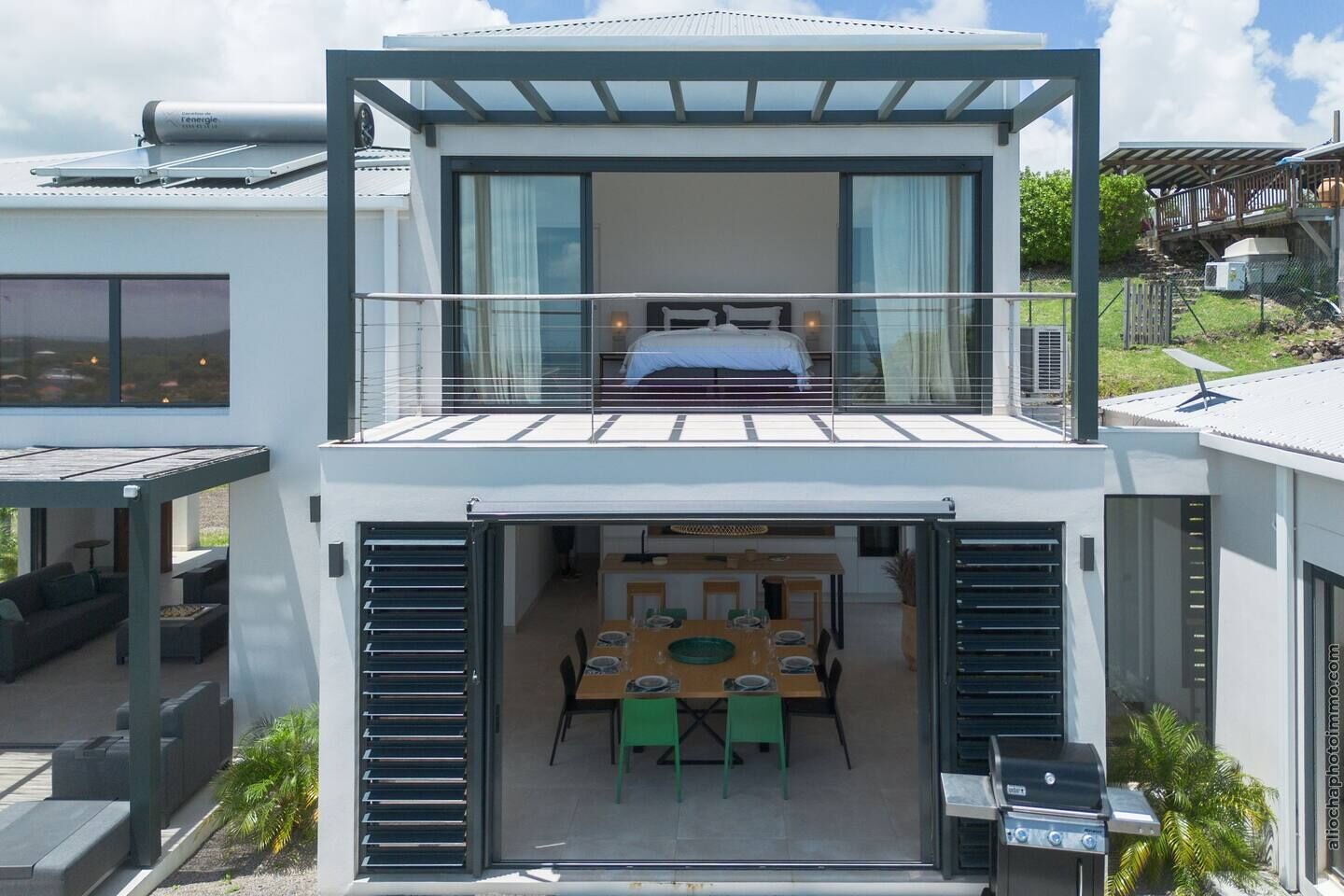 Una casa moderna de dos pisos, con balcón, comedor y patio.