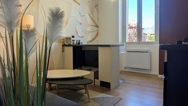 Een moderne keuken met een ronde eettafel, een inbouwfornuis en een raam met uitzicht op de omgeving.