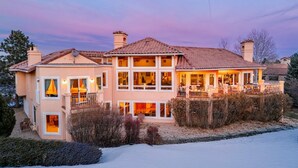 A multi-story house with a balcony, large windows, and a well-lit interior. - Pikes Peak Place: Relaxing Oasis w/Mtn Views (Colorado Springs)