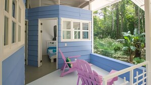 Una habitación con fachada azul, una ventana, una cama y una silla.