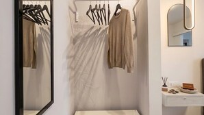 Une salle de bain moderne avec un miroir, un porte-serviettes et des tiroirs de rangement.