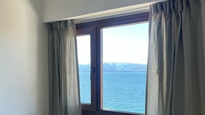 A room with a bed, a radiator, and a window with curtains. - Del Lago Sky Hotel (San Carlos de Bariloche)