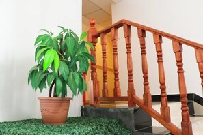 Een trap met houten spijbels en een bloempot ernaast.