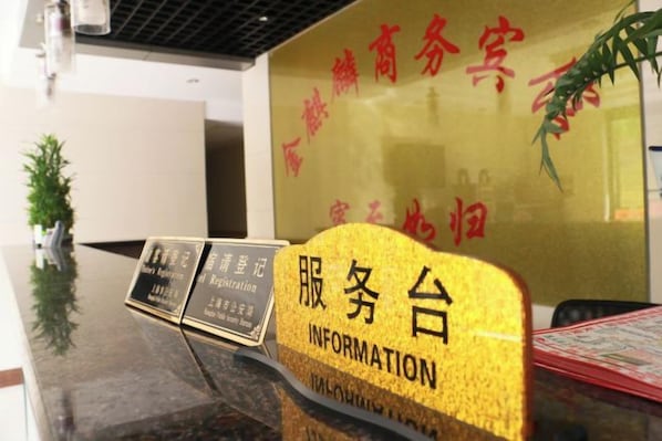 A reception desk with a sign that reads 'Information' and a digital display board. - Jinqilin Hostel (Shanghai Waigaoqiao Free Trade Zone) (Shanghai)