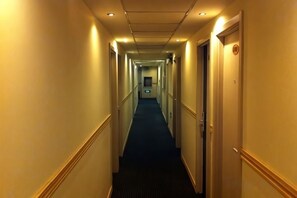 A hotel corridor with doors on both sides, a carpeted floor, and a ceiling with recessed lighting. - Jinqilin Hostel (Shanghai Waigaoqiao Free Trade Zone) (Shanghai)