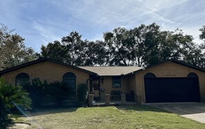 Une maison à deux étages avec un garage, un porche à l’avant et une pelouse.