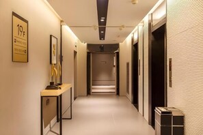 A hotel corridor with a reception desk, framed artwork, and a wall-mounted sign. - Guangzhou Zhujiang New Town Homeinn Selected Hotel (Guangzhou)