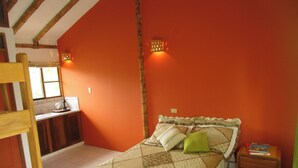 A bedroom with a bed, a nightstand, a wooden ladder, and a window.