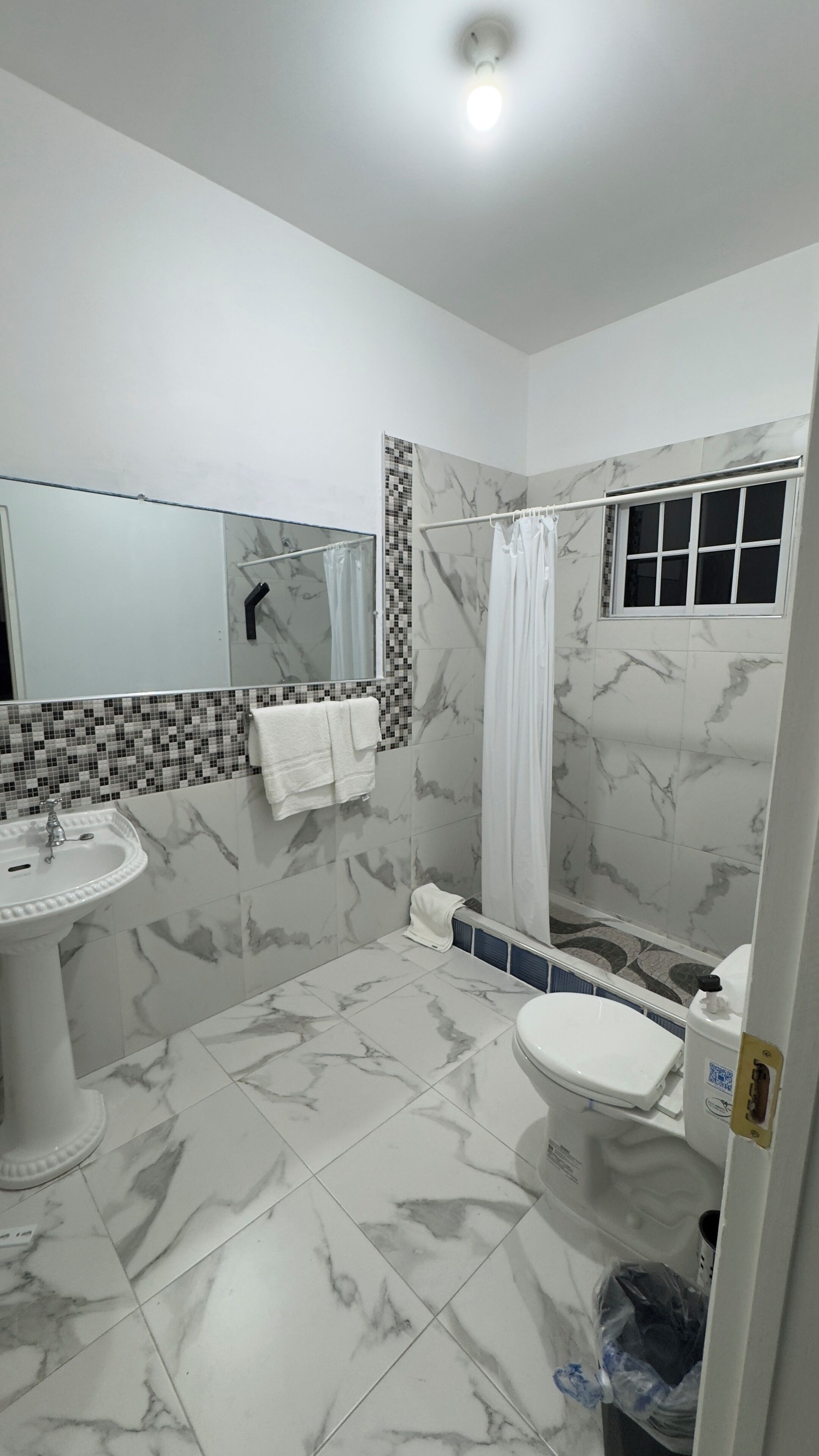A bathroom with a sink, toilet, and shower area.