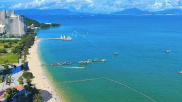 A coastal area with a beach, boats, and a bridge.