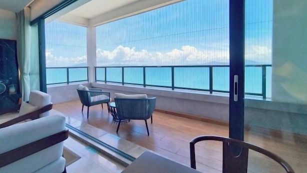 A modern interior with large windows, a balcony, and a seating area. - Huidong Xunliao Bay New Coast Scenic Hotel (Haigongyuan Leisure Beach) (Huidong)