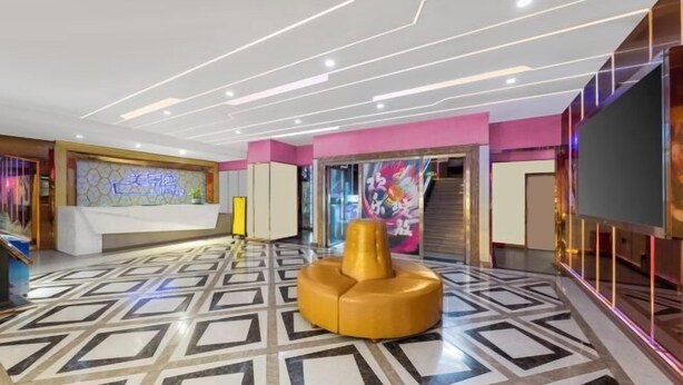 A modern lobby with a geometric patterned floor, a reception desk, and a unique yellow seating area. - Meijingwan Hostel (Shenzhen)
