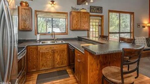 Una cocina con armarios de madera, una isla grande y un letrero que dice 'HOME'.