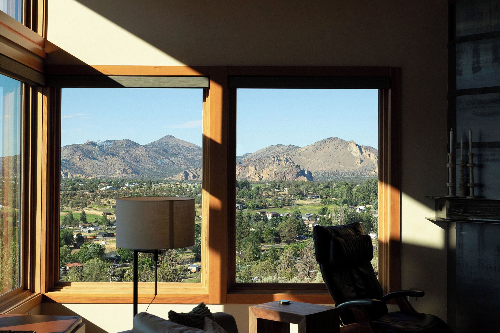 A room with large windows offering a view of mountains and a valley.