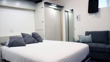 Escritorio, tabla de planchar con plancha, wifi y ropa de cama