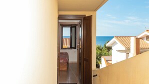 Un couloir étroit mène à une chambre avec vue sur la mer.
