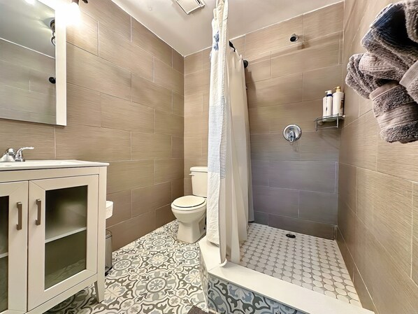 Un baño con ducha, inodoro y lavamanos.