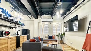Un espace de vie moderne comprenant une cuisine, un canapé gris et un coin repas.