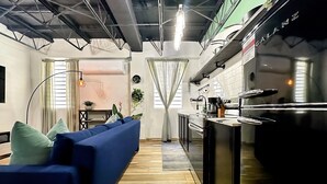Une cuisine moderne dotée d’une cuisinière intégrée et d’un coin repas avec un canapé bleu et une table à manger.