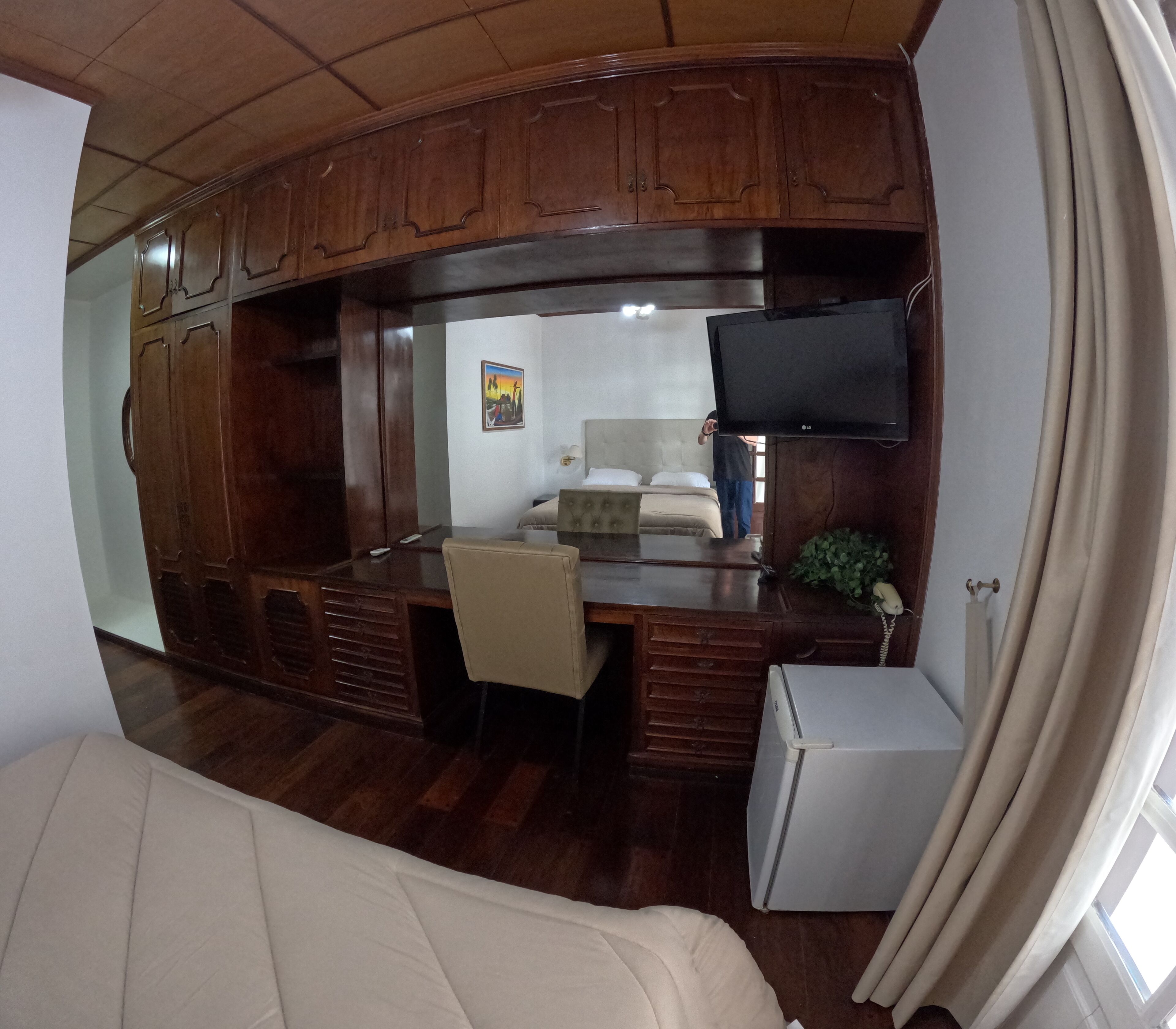 A compact RV interior with a kitchenette, a bed, and a seating area.