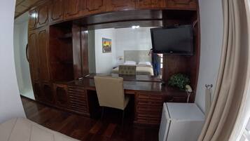 A compact RV interior with a kitchenette, a bed, and a seating area.