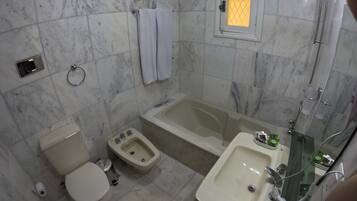 Un baño con inodoro, bidé, bañera y lavamanos.