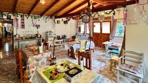 A cozy, rustic dining area with wooden furniture and a tiled floor. - Mama Eva House (Lago Puelo)