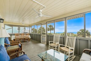 A covered outdoor area with a ceiling fan, wicker furniture, and a glass table. - 5BR 4BA OF Beach House. LOTS of Charm (North Myrtle Beach)