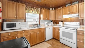 A kitchen with wooden cabinets, a microwave, a coffee maker, and a stove. - 5BR 4BA OF Beach House. LOTS of Charm (North Myrtle Beach)