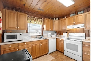 A kitchen with wooden cabinets, a microwave, a coffee maker, and a stove. - 5BR 4BA OF Beach House. LOTS of Charm (North Myrtle Beach)