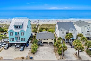 Une zone résidentielle côtière avec des maisons, une plage et un ciel dégagé.