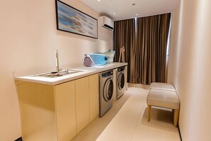 A compact kitchen with a washing machine, a sink, and a countertop. - Guiyuan Hotel (Foshan Lingnan Tiandi Oriental Plaza Branch) (Foshan)