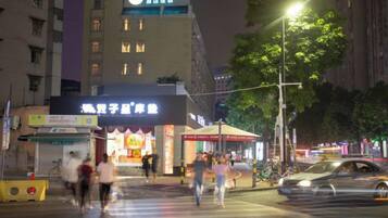 A street scene at night with a building that has a sign for a restaurant and a crosswalk.
