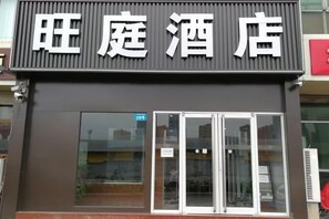 A hotel with a modern facade, large glass windows, and a prominent signage.