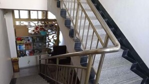 Una escalera con barandilla de metal y peldaños blancos y negros.