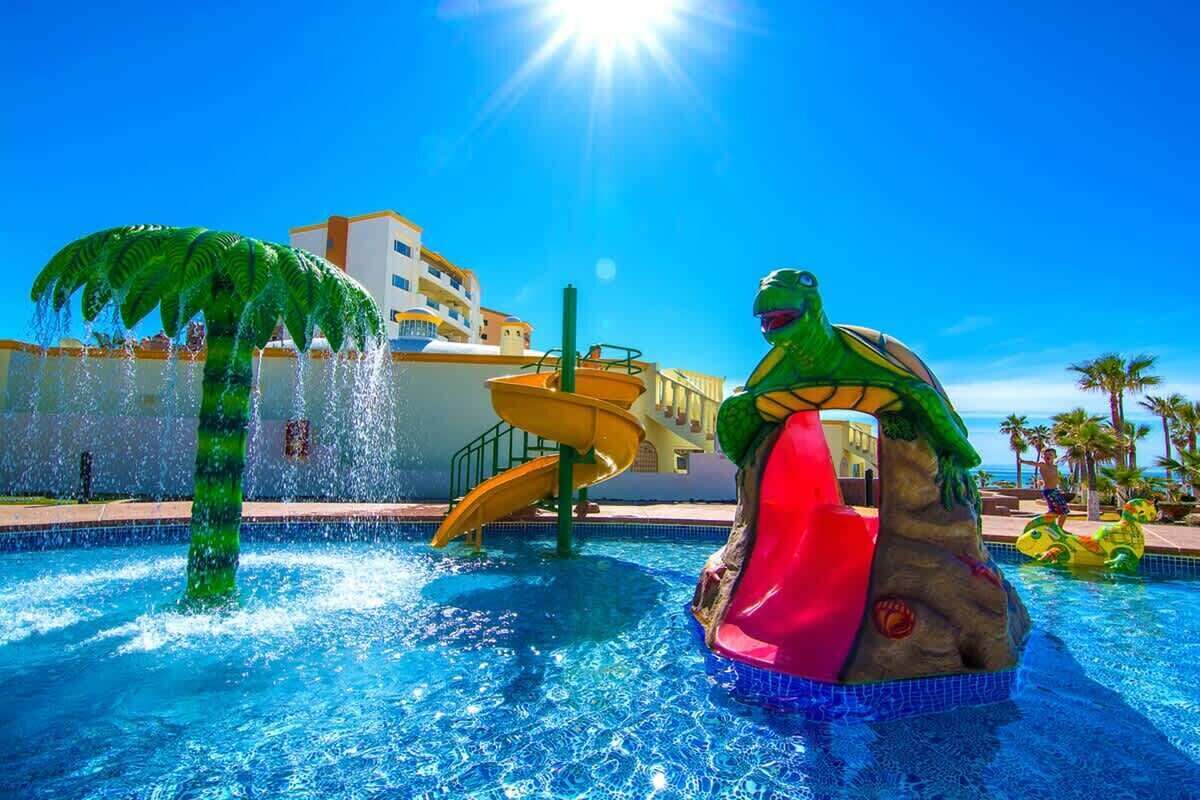 En pool med en vattenrutschkana och en stor uppblåsbar sköldpadda.