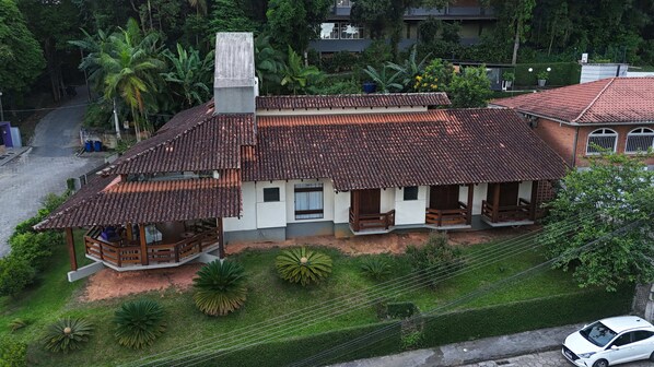 Una casa de dos pisos con techo de tejas, un balcón y un pequeño porche.