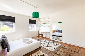 1 habitación, escritorio y tabla de planchar con plancha