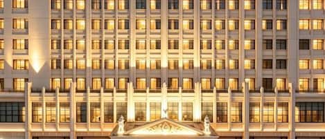 Un hôtel à plusieurs étages, doté d’une façade symétrique, avec une entrée centrale surmontée d’un fronton et portant l’inscription « VIENNA ».