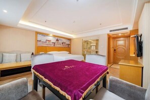 Ein Hotelzimmer mit Bett, Schreibtisch, Sessel, Sofa und einem Bild an der Wand.