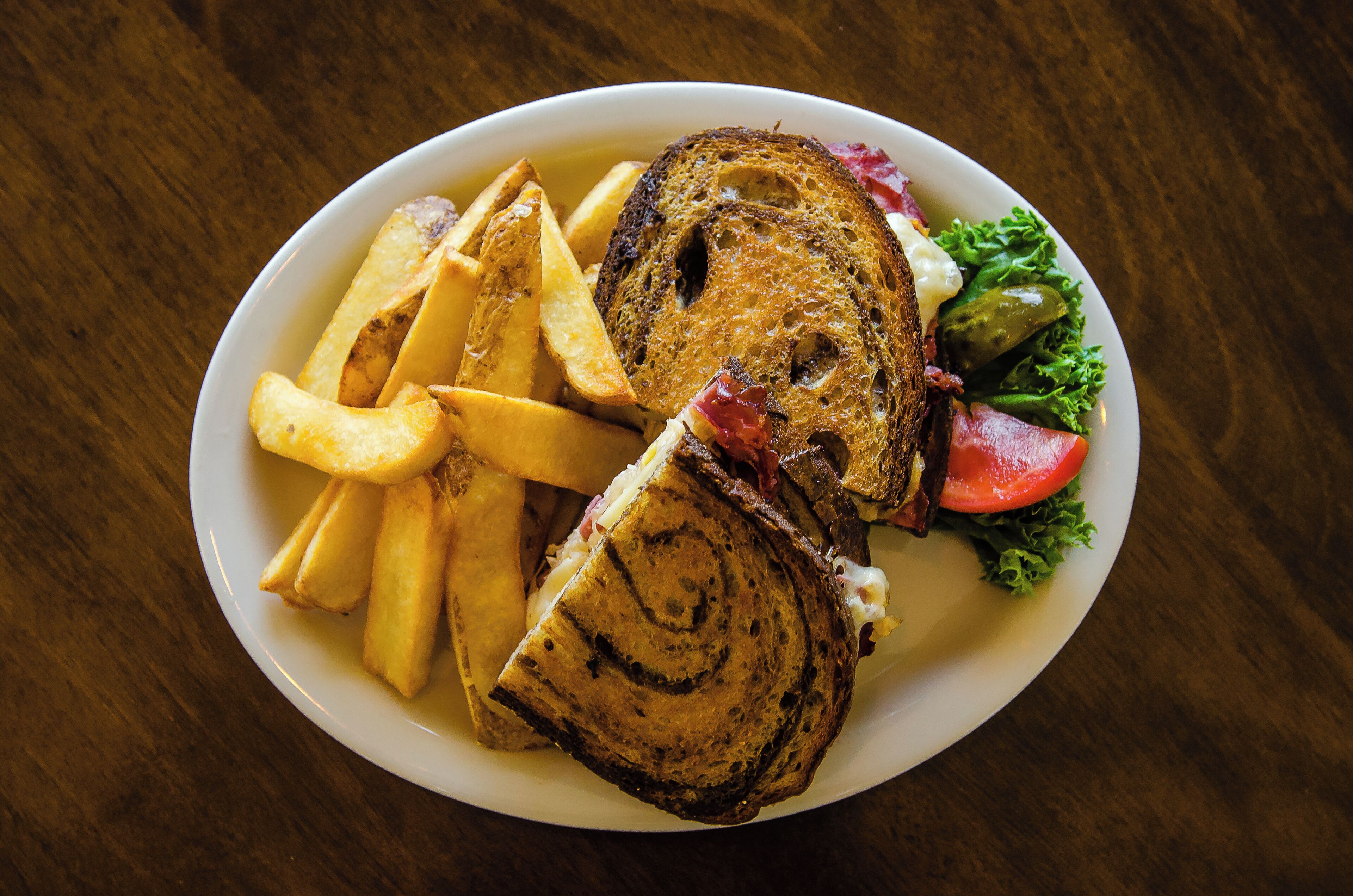 Un plato con un sándwich, papas fritas y una ensalada.