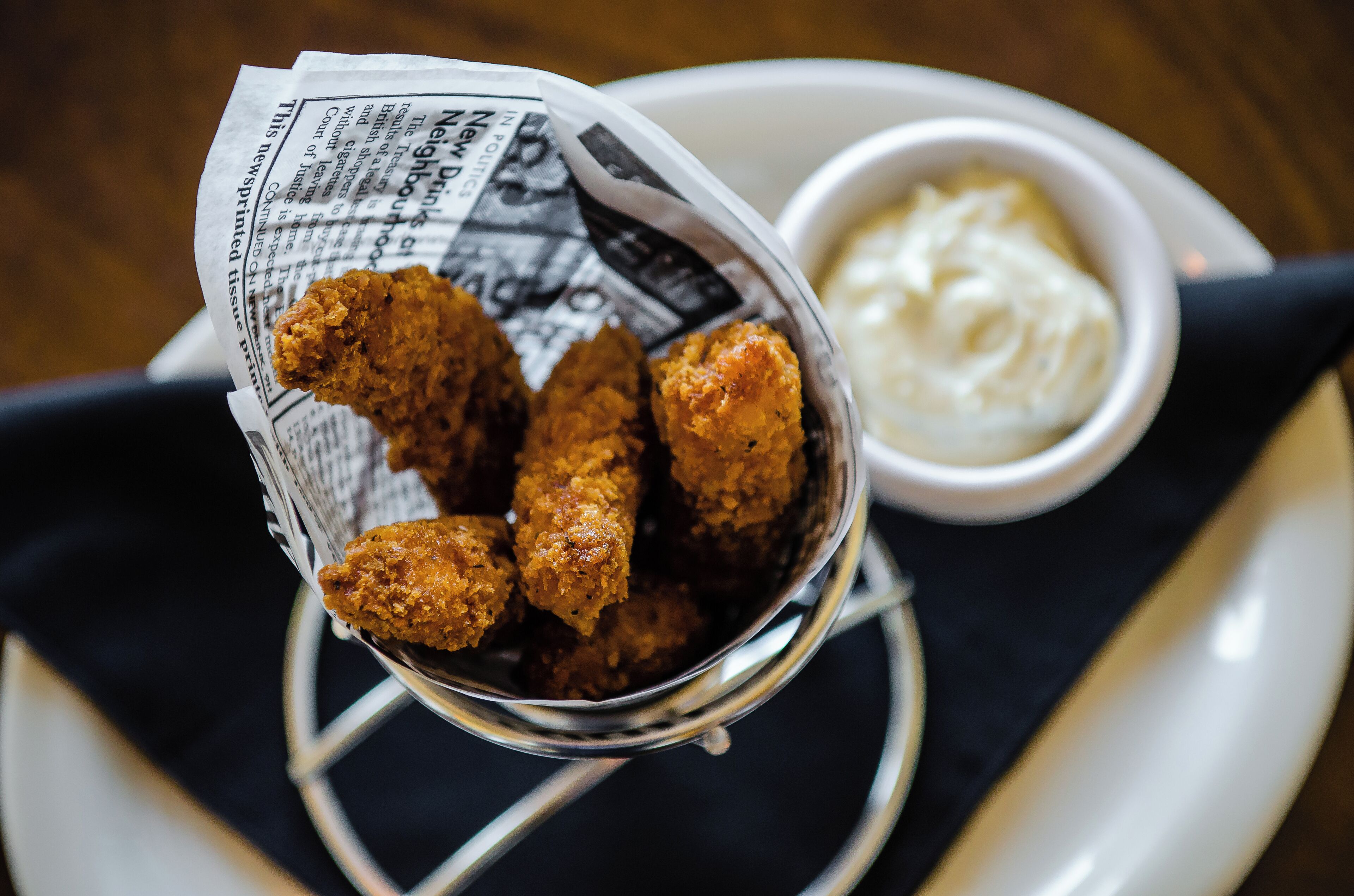Un panier d’ailes de poulet frites, accompagné d’une sauce pour tremper.