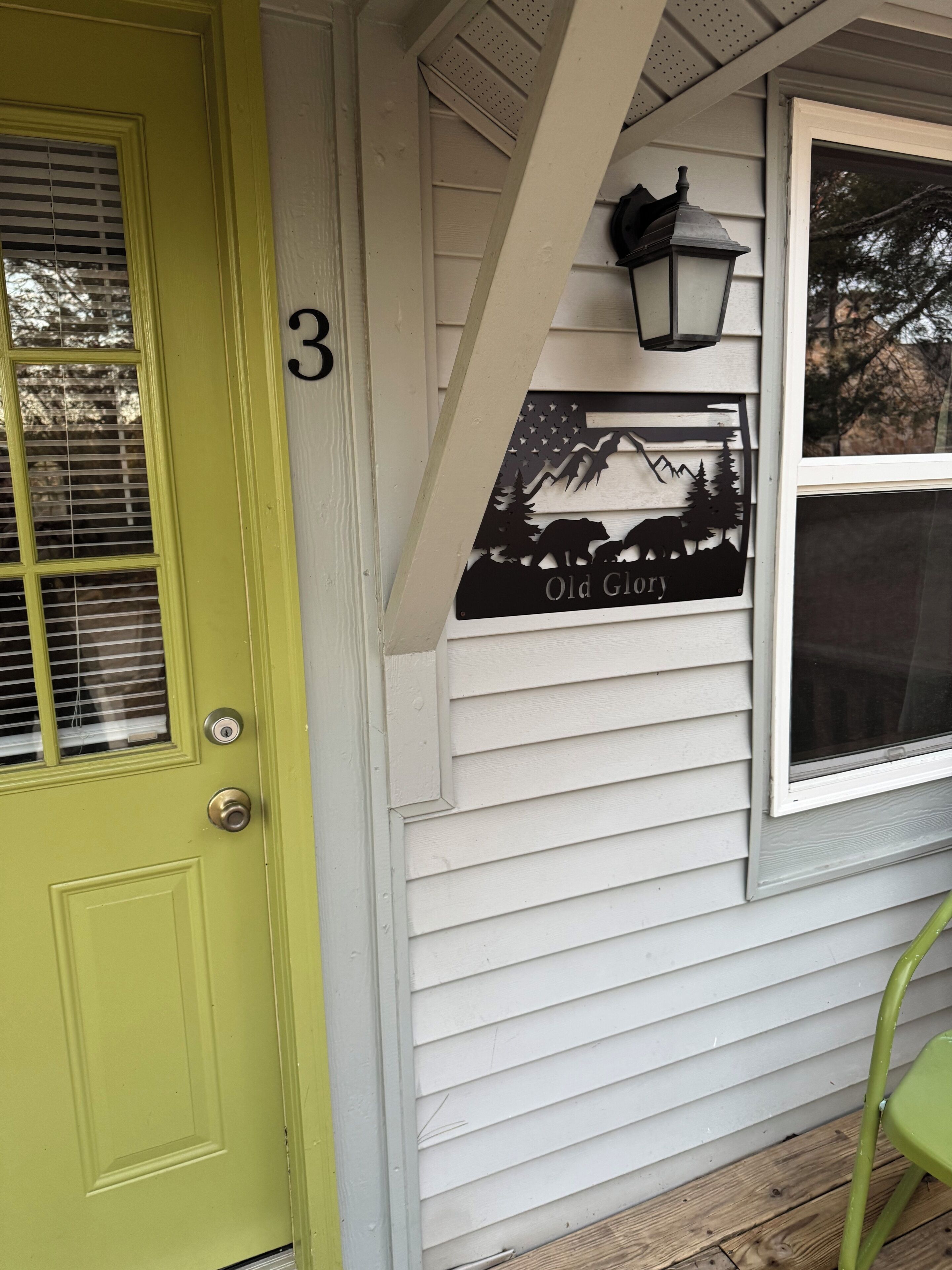 A house with a green door and a sign that reads "Old Glory."